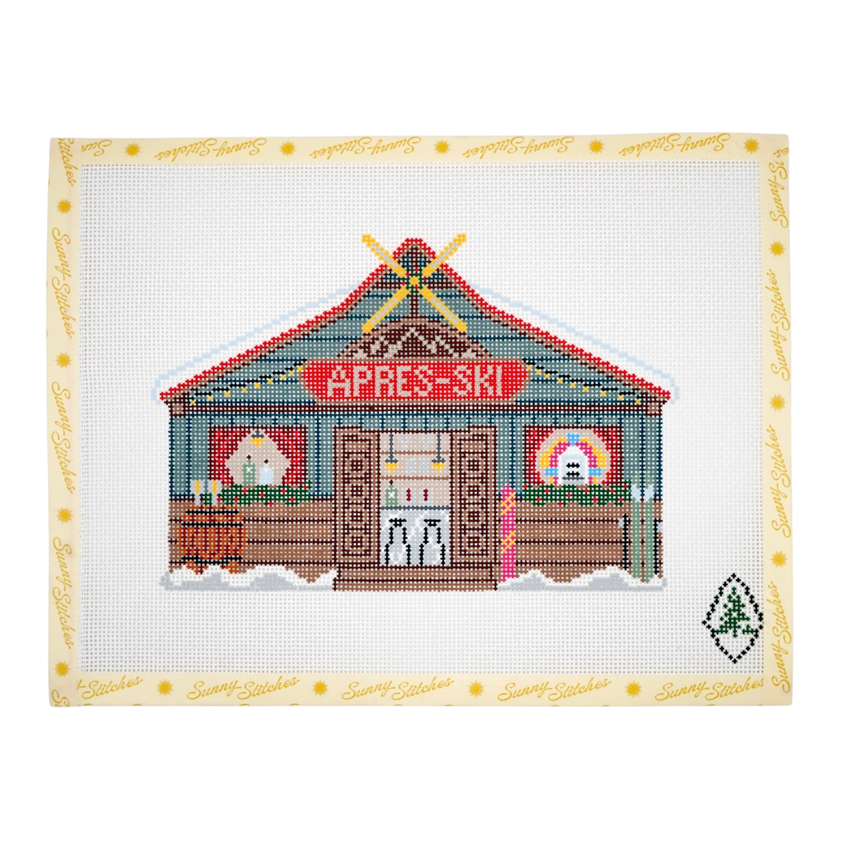 A completed cross-stitch design of a rustic ski lodge with the words 'APRES-SKI' on the front.