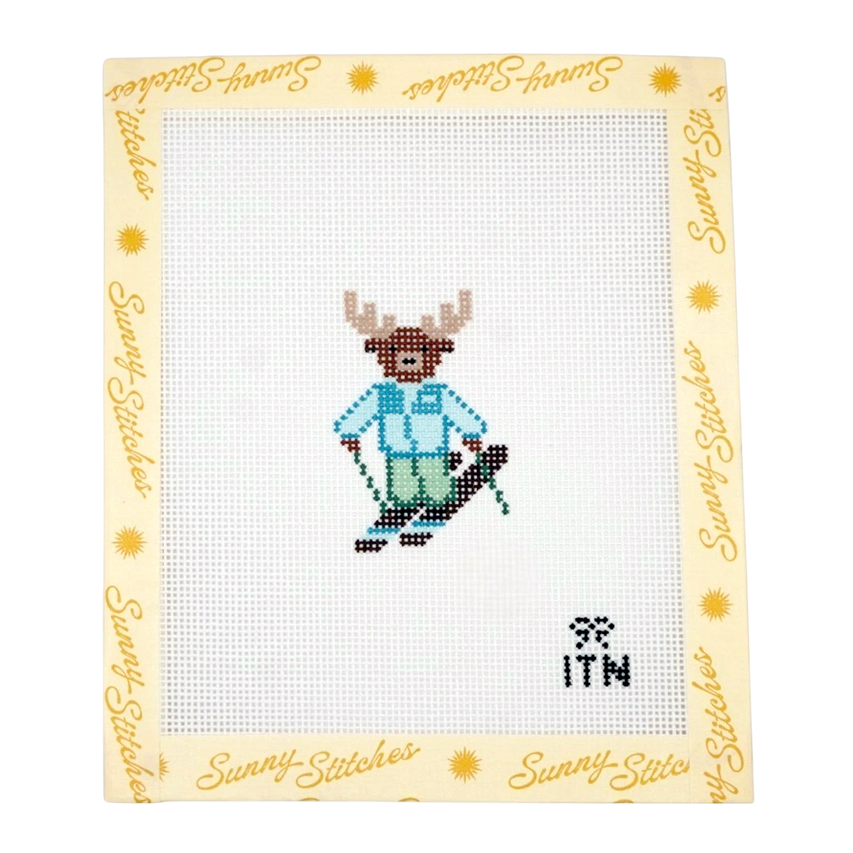A cross-stitch sampler by Sunny Stitches featuring a pixelated skiing moose on white needlepoint canvas, surrounded by a cream border printed with the Sunny Stitches brand name and sun motifs.